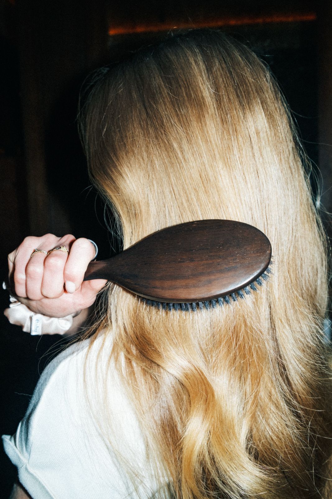 vrouw borstelt lang blond haar met de boar bristle brush